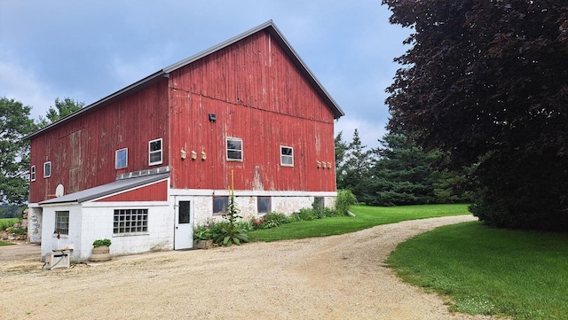 view of home's exterior with a yard, a barn, and an outdoor structure