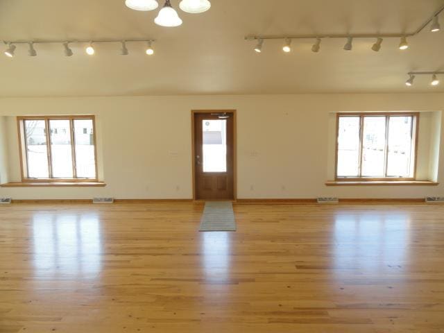 empty room featuring plenty of natural light, light wood-style floors, and a chandelier