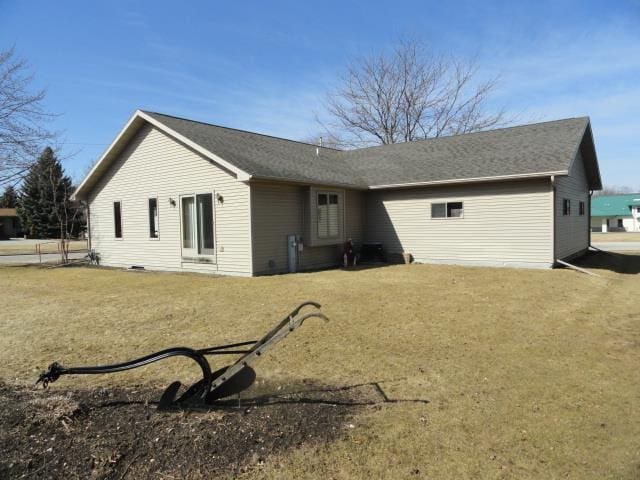 rear view of property featuring a lawn