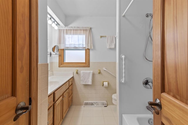 full bathroom featuring tile patterned flooring, visible vents, a wainscoted wall, toilet, and tile walls