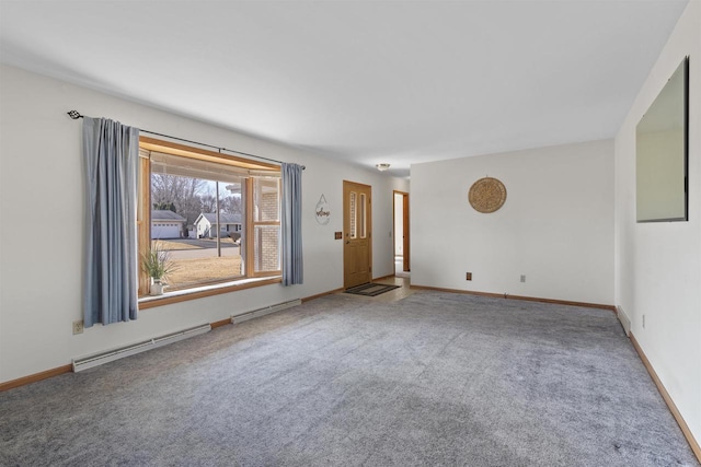 spare room featuring a baseboard heating unit, baseboards, and carpet flooring