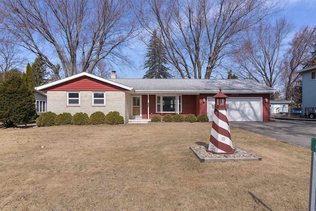 ranch-style house featuring aphalt driveway, a front yard, a garage, brick siding, and a chimney