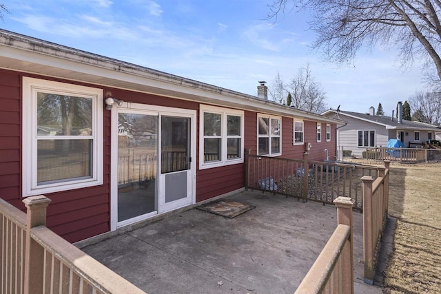 rear view of property featuring a patio area and a chimney