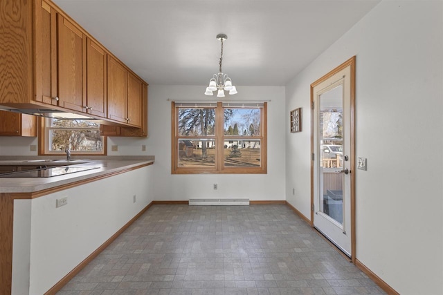 unfurnished dining area featuring a wealth of natural light, baseboard heating, baseboards, and an inviting chandelier