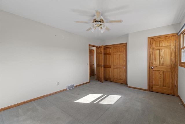 unfurnished bedroom featuring visible vents, baseboards, carpet, a closet, and a ceiling fan