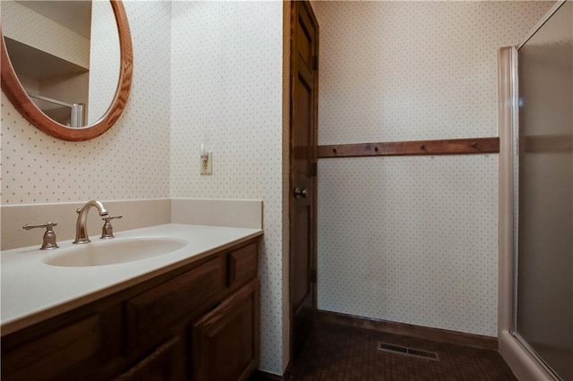 bathroom featuring a shower with door, visible vents, wallpapered walls, and vanity