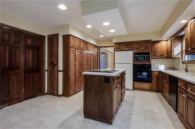 kitchen featuring a kitchen island, recessed lighting, a sink, black appliances, and light countertops