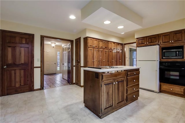 kitchen featuring oven, freestanding refrigerator, stovetop, light countertops, and built in microwave