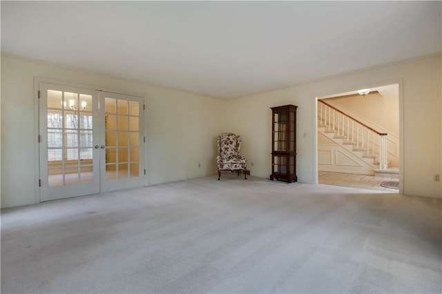 empty room featuring stairway, french doors, and carpet floors