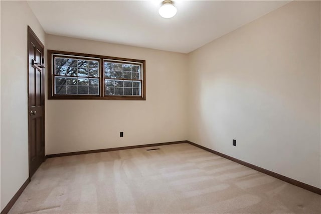 empty room with light colored carpet and baseboards