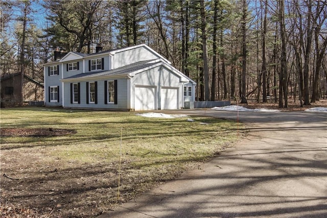 view of outbuilding featuring aphalt driveway and an attached garage