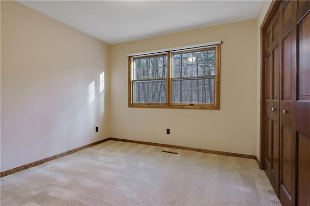 interior space with visible vents, baseboards, and light carpet