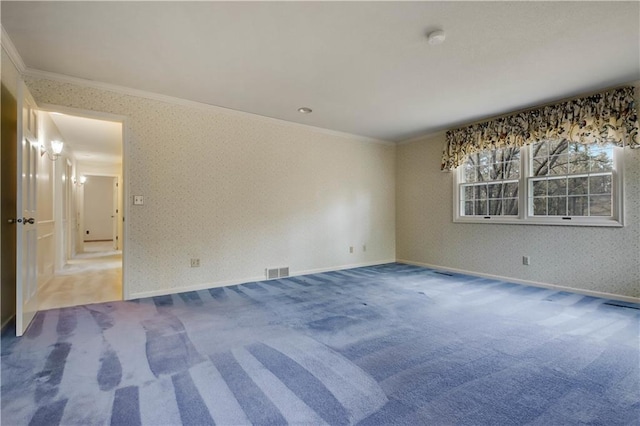 carpeted spare room with visible vents, baseboards, crown molding, and wallpapered walls