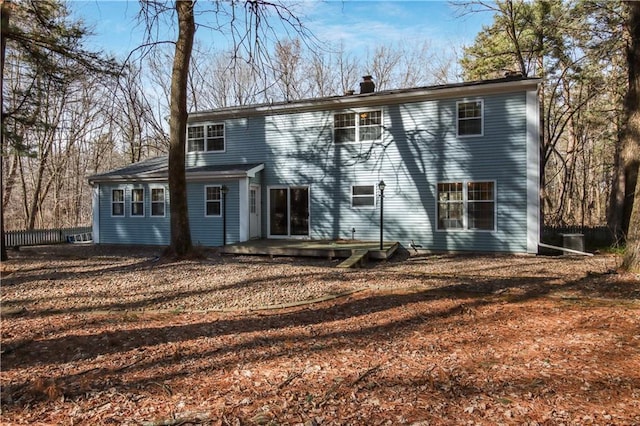 back of property with a wooden deck and a chimney