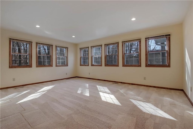 spare room featuring recessed lighting, baseboards, and light carpet