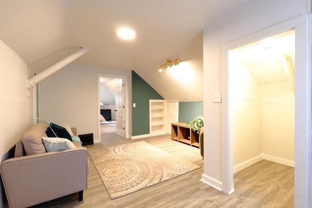 bonus room featuring baseboards, vaulted ceiling, and light wood finished floors