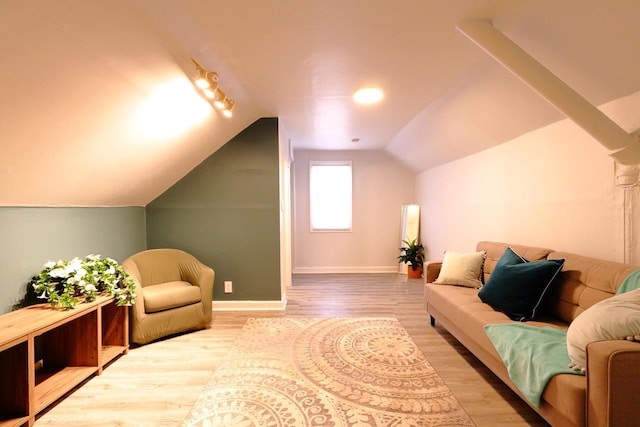 interior space with baseboards, lofted ceiling, and wood finished floors