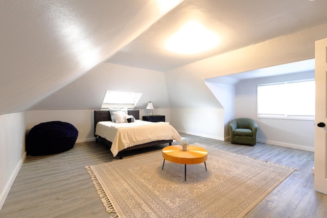 bedroom with lofted ceiling, wood finished floors, and baseboards