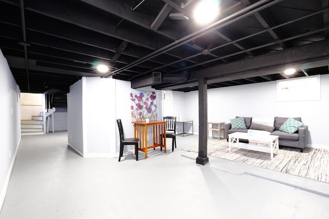 finished basement featuring visible vents, stairs, and baseboards