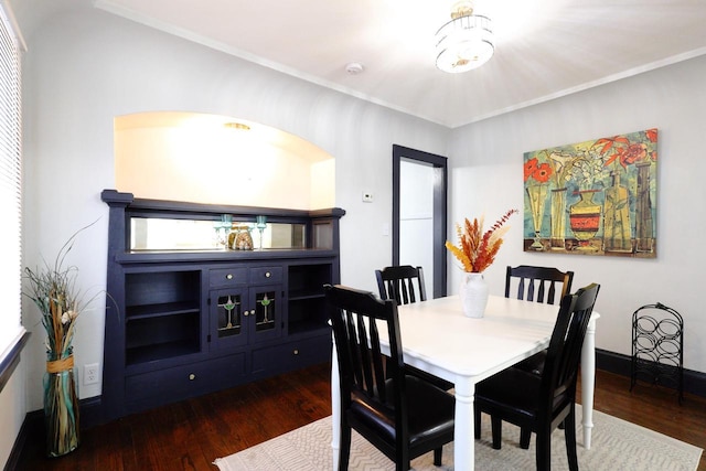 dining space with crown molding and dark wood-style flooring