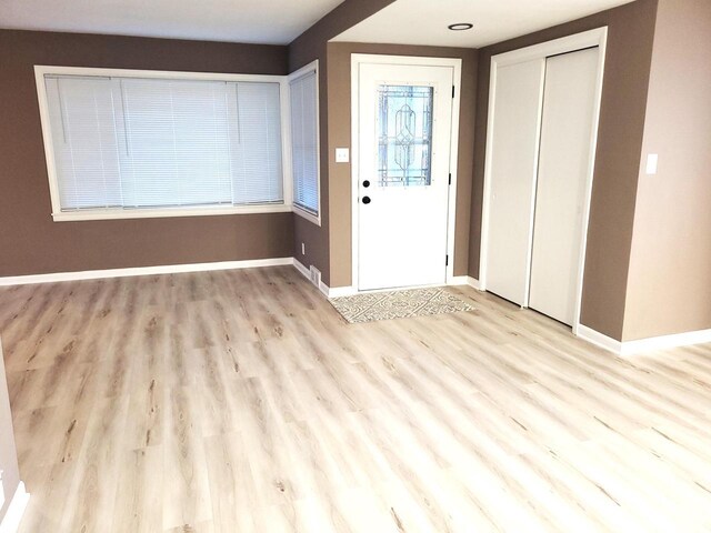 entryway with wood finished floors and baseboards