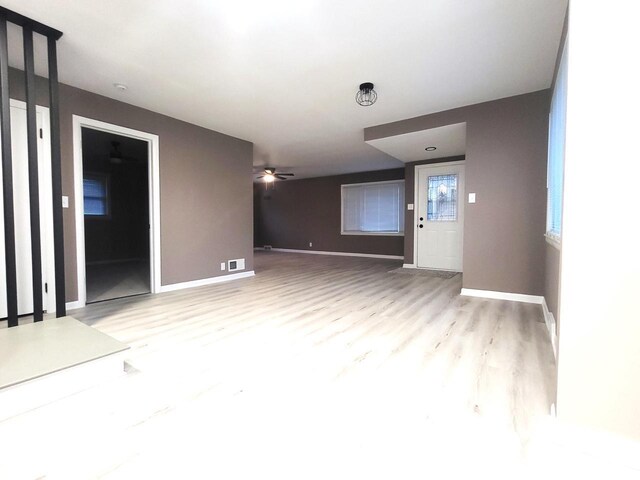 unfurnished room featuring a ceiling fan, wood finished floors, and baseboards