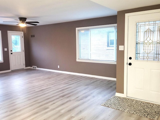 entryway featuring ceiling fan, visible vents, baseboards, and wood finished floors