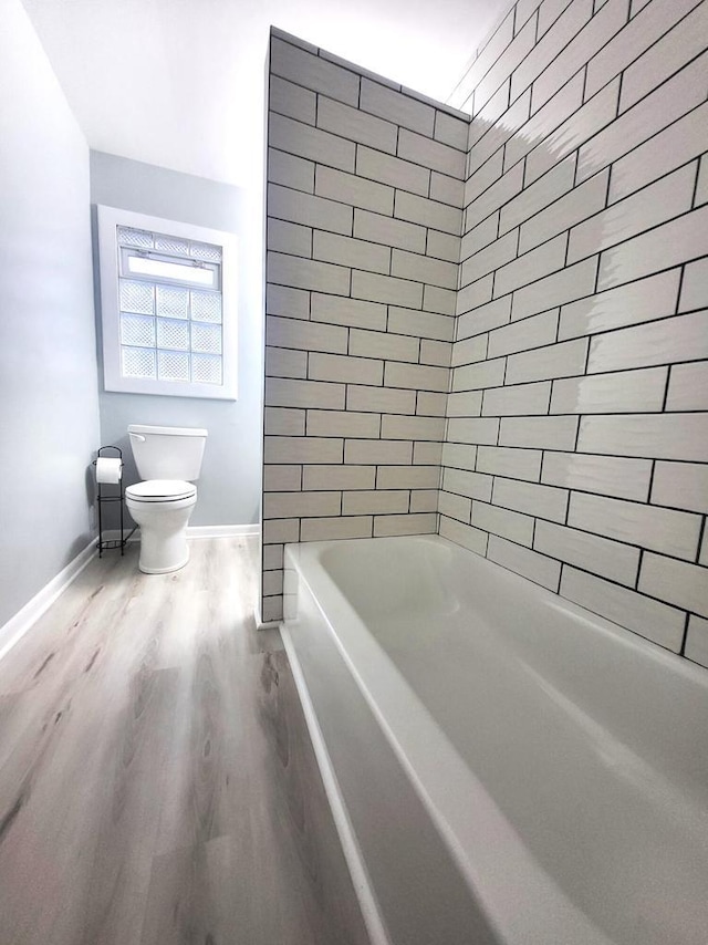 full bath with toilet, wood finished floors, and baseboards