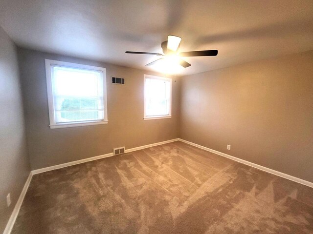 empty room featuring visible vents, baseboards, carpet, and ceiling fan