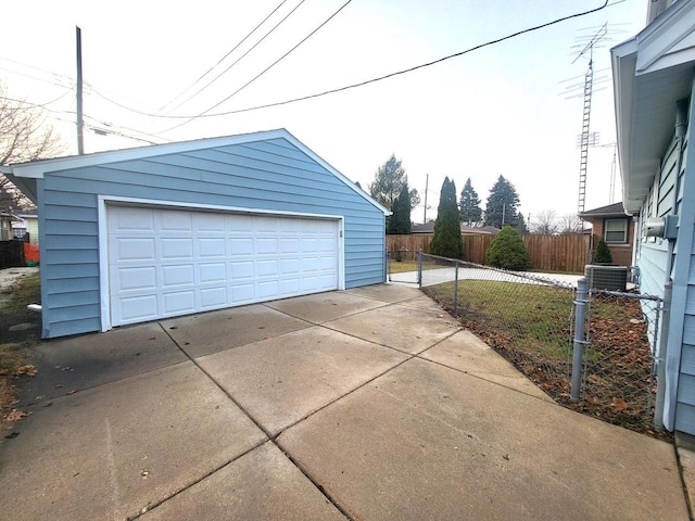 detached garage featuring cooling unit and fence