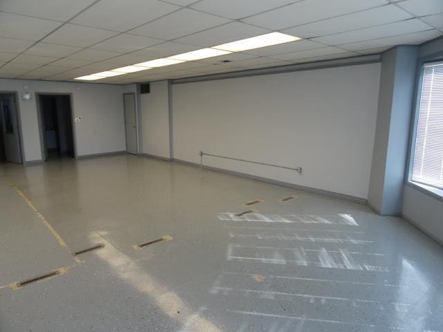 unfurnished room with baseboards and a paneled ceiling