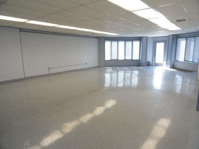 spare room with visible vents, a paneled ceiling, and speckled floor