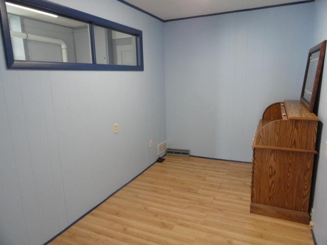 spare room featuring wood finished floors and visible vents