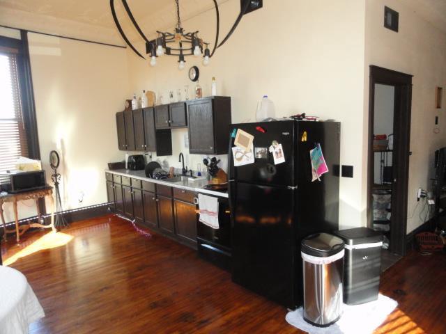 kitchen featuring black appliances, a notable chandelier, dark wood-type flooring, and a sink