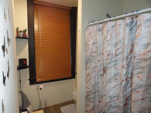 full bathroom featuring curtained shower and toilet