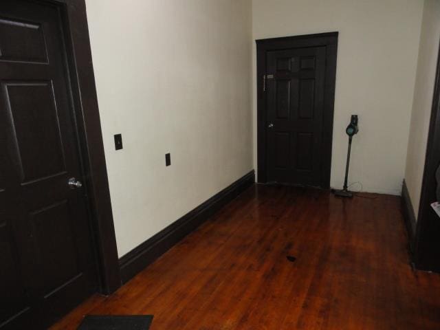 hallway with wood finished floors and baseboards