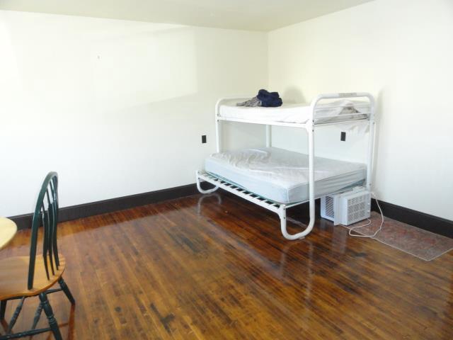 bedroom with wood finished floors and baseboards