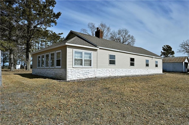 N7030 Little Valley Rd, Spooner, WI 54801 - view of side of property with a lawn, an outdoor structure, and a chimney