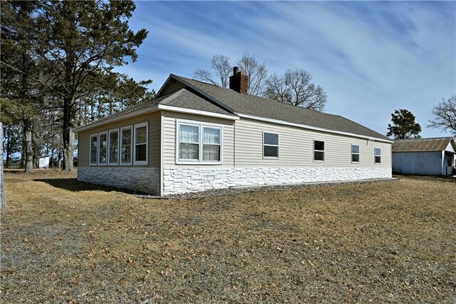 N7030 Little Valley Rd, Spooner, WI 54801 - view of side of property featuring an outdoor structure, a lawn, and a chimney