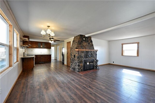 N7030 Little Valley Rd, Spooner, WI 54801 - unfurnished living room with plenty of natural light, dark wood-type flooring, a stone fireplace, and a chandelier