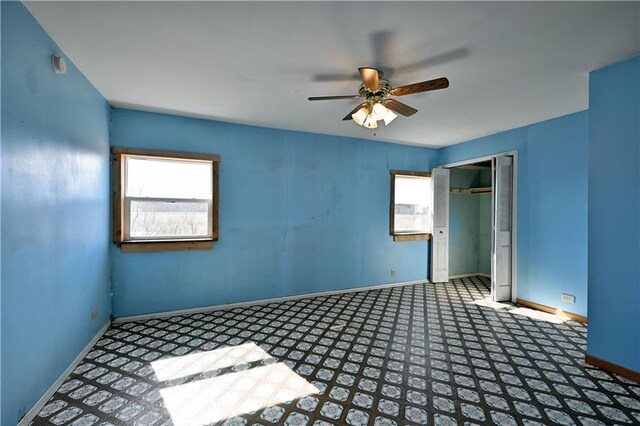 N7030 Little Valley Rd, Spooner, WI 54801 - unfurnished bedroom featuring tile patterned floors, a closet, baseboards, and a ceiling fan