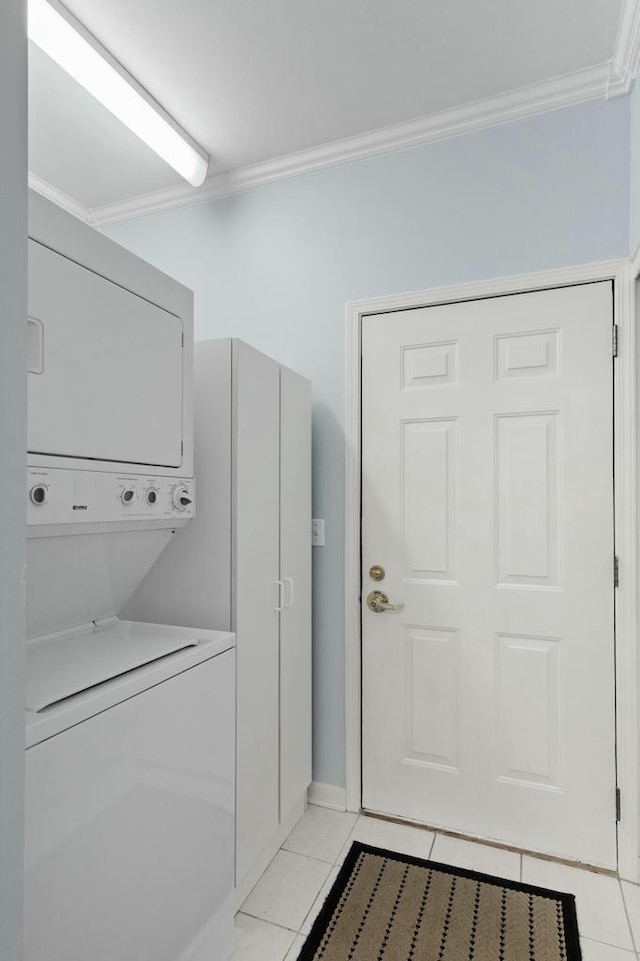 laundry area featuring laundry area, light tile patterned floors, stacked washer and clothes dryer, and ornamental molding