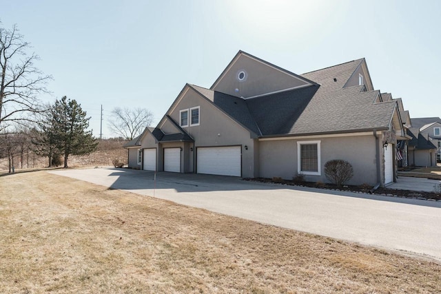 view of front facade featuring a shingled roof, concrete driveway, a garage, and stucco siding