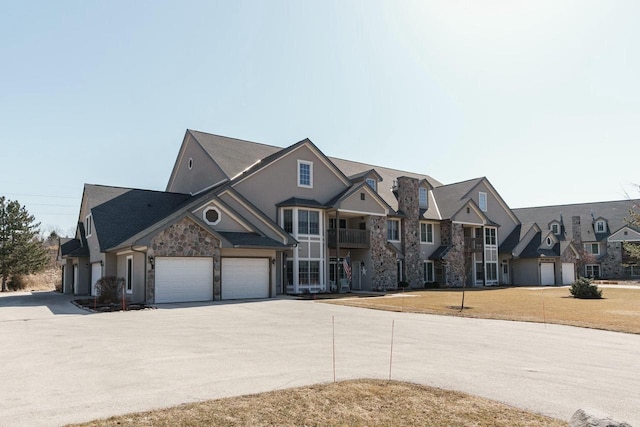 view of front of property with concrete driveway, stone siding, and a residential view