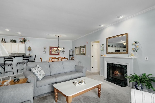 living room featuring light carpet, recessed lighting, an inviting chandelier, a fireplace, and crown molding