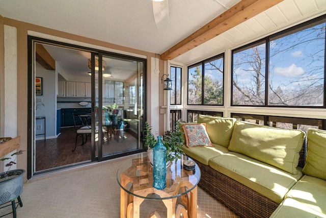 sunroom / solarium featuring beamed ceiling, a healthy amount of sunlight, and a ceiling fan