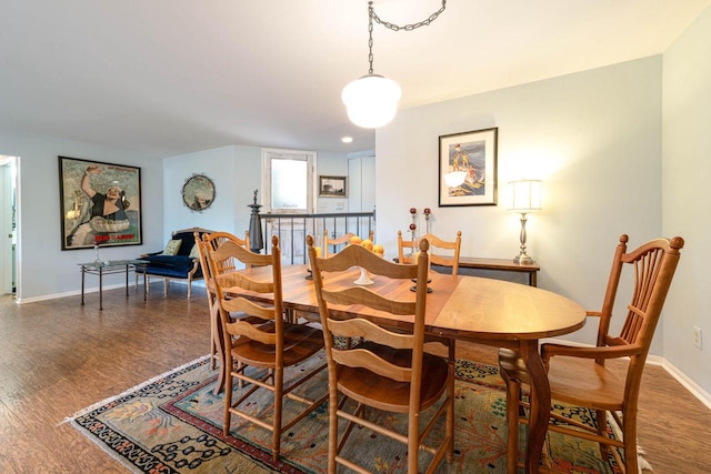 dining space featuring baseboards and wood finished floors