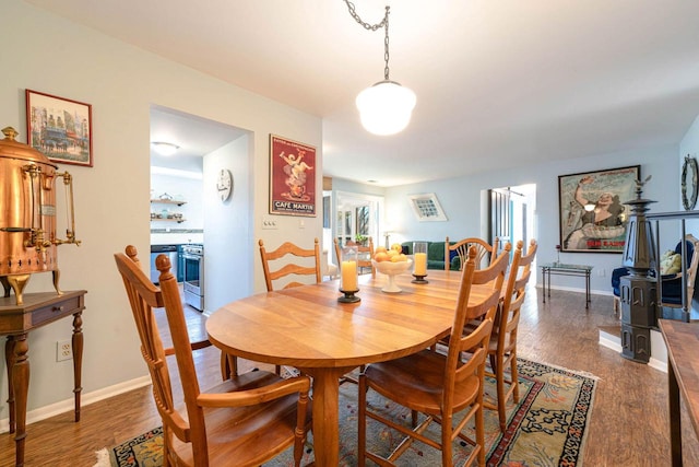 dining area with baseboards and wood finished floors