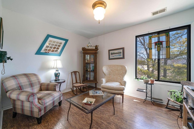 sitting room featuring visible vents, baseboards, and wood finished floors