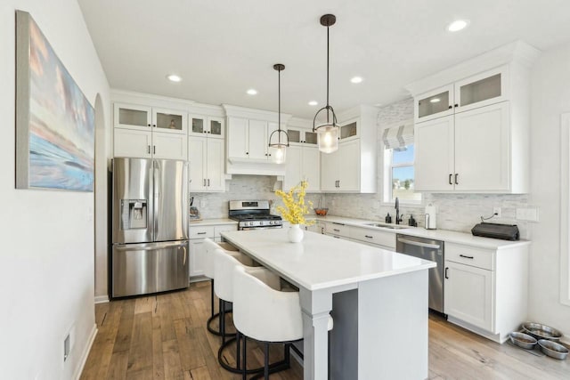 kitchen featuring white cabinets, backsplash, appliances with stainless steel finishes, and a sink